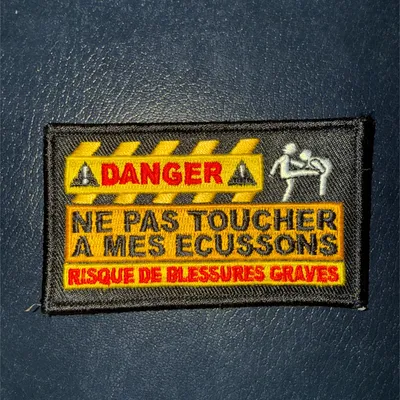 DANGER - ne pas toucher mes écussons - Risque de blessures grave 